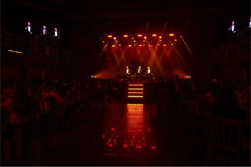 Concierto con iluminación roja y público frente al escenario